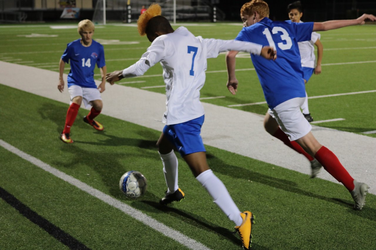 Yoni Southwick pushes the ball past two Leander defenders during tonight's 2-0 varsity loss to the Lions tonight at House Park. Photo by J. R. Cardenas.