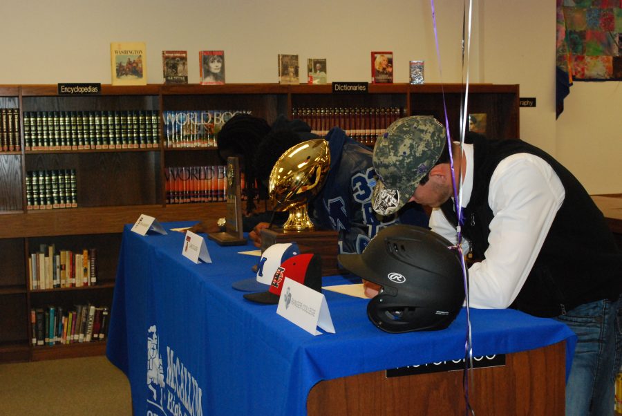 Three seniors sign the dotted line