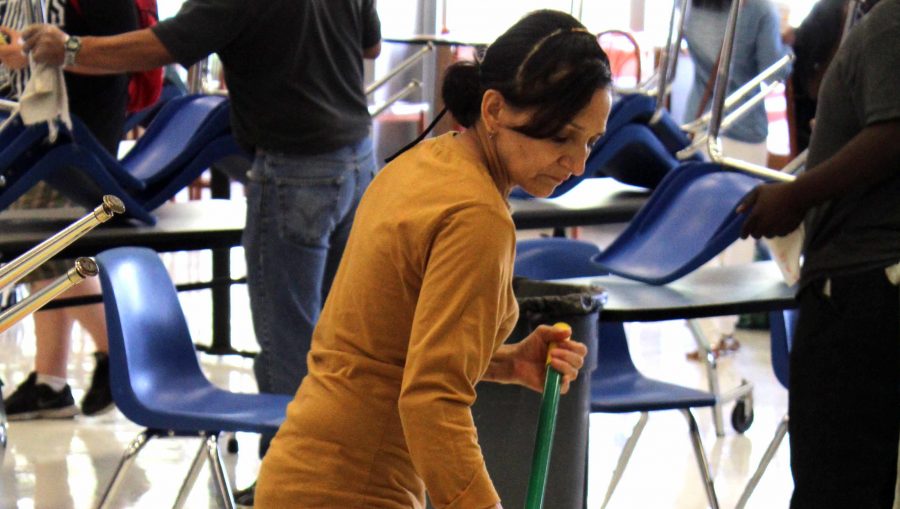 Custodian Maria Mendoza sweeps the cafeteria at the end of lunch.