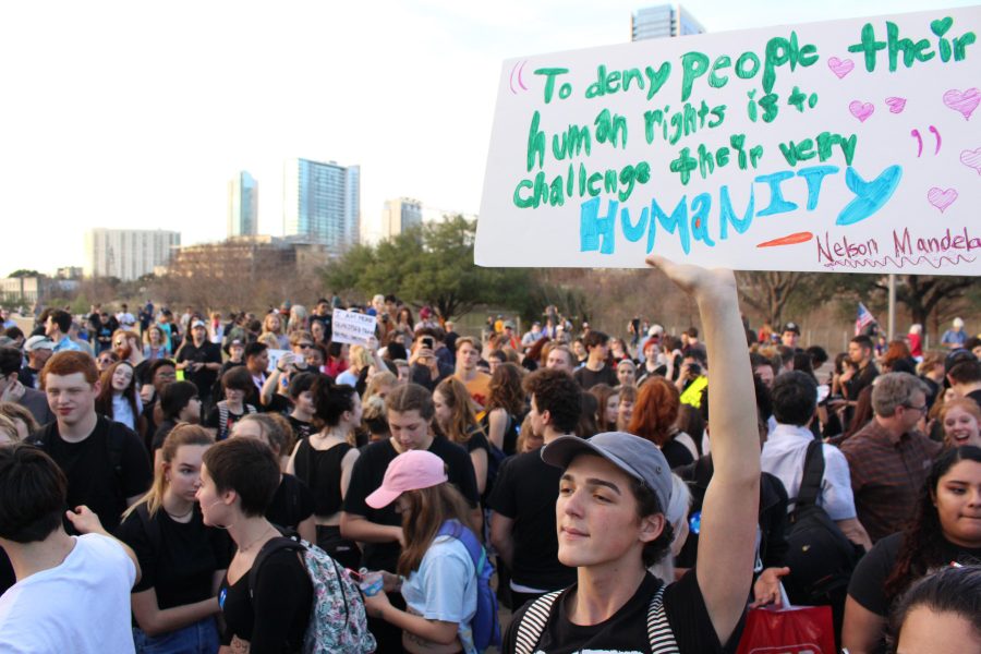 Junior Marley Bell displays a sign quoting Nelson Mandela at the Inauguration Day protest on January 20 at Auditorium shores. Bell was one of the estimate 150 students from McCallum that chose to participate in anti-Trump rallies on the day he was sworn into office. “I think that it’s going to be a long time before we can get completely gender neutral bathrooms, but I know for certain that it’s a matter if these individuals taking it upon themselves to be aware of the problems and to fix them as well as committing to educate people about gender neutral bathrooms, because the more educated people are the more comfortable people are.” Photo by Madison Olsen.