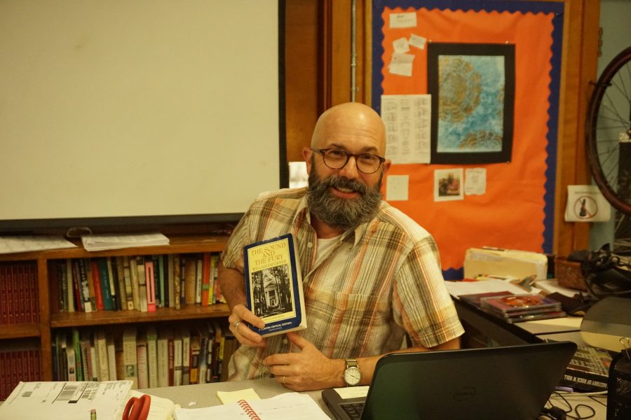 Mr. Watterson poses with his favorite book. Photo by Madison Olsen.