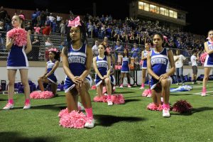 TAKING A STAND BY KNEELING DOWN:  Members of the McCallum cheerleaders, for the 4th week, kneeled during the pledge of allegiance at the Knights win over the Crockett Cougars 55-0. The cheerleaders are participating in the #Takeaknee movement that has swept the NFL in recent weeks. photo by Madison Olsen