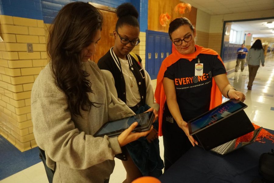 Sophomores Desaray Trevino and Aaliyah Cruz talk to AISD technology design coach Rita Fennelly-Atkinson about the Chromebooks students will receive in January. During lunch last week, Fennelly-Atkinson demonstrated the new laptops and how to use them. Photo by Maddie Doran. 