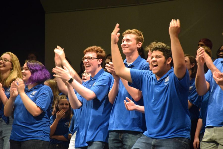 Seniors Tryston Davis (left) and Wilson Caballero (right) cheer on McCallum Choir alumni as they join the current choir onstage. At the end of the last concert, former Mac choir members are invited to sing "The Lord Bless You and Keep You" by Lutkin. It is sung at the end of each choir concert to say goodbye to the audience. "I love it when the alumni come up and sing with us," Davis said. "It's so fun to see everyone again and get them back onstage." Photo by Jazzabelle Davishines.