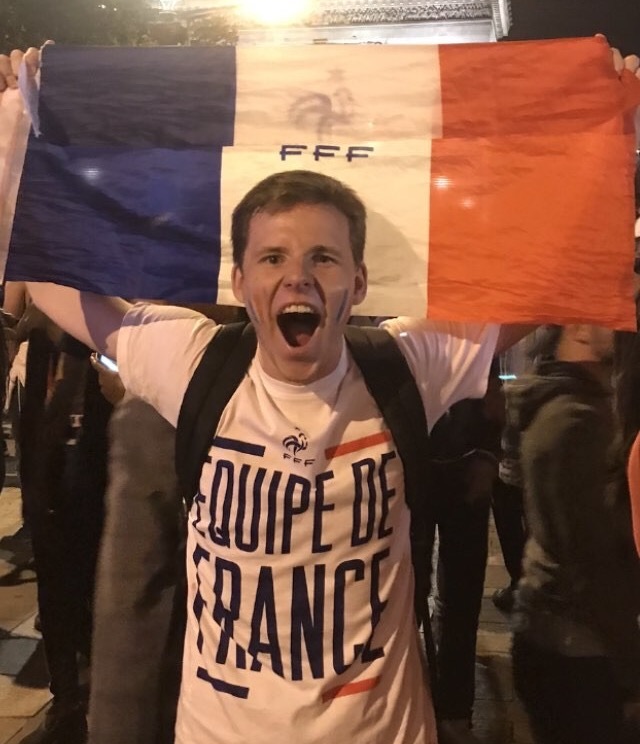 Vincent McKenna holds up a French flag while celebrating Frances 1-0 win over Belgium on Tuesday at Champs-Elysees Avenue. The win moved France on to the finals where they will play Croatia on Sunday. Photo courtesy of Vincent McKenna.