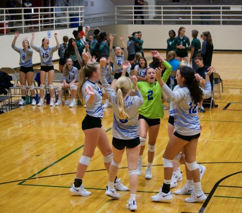 The team on the court and on the bench celebrate the teams 2-1 victory over Desoto, the teams fifth victory in a row and sixth in eight matches at the AISD Jason Landers Memorial tournament.