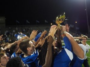 THREEPEAT: The Knights hoist the Taco Shack Trophy after winning the annual game 21-20. Photo by Gregory James
