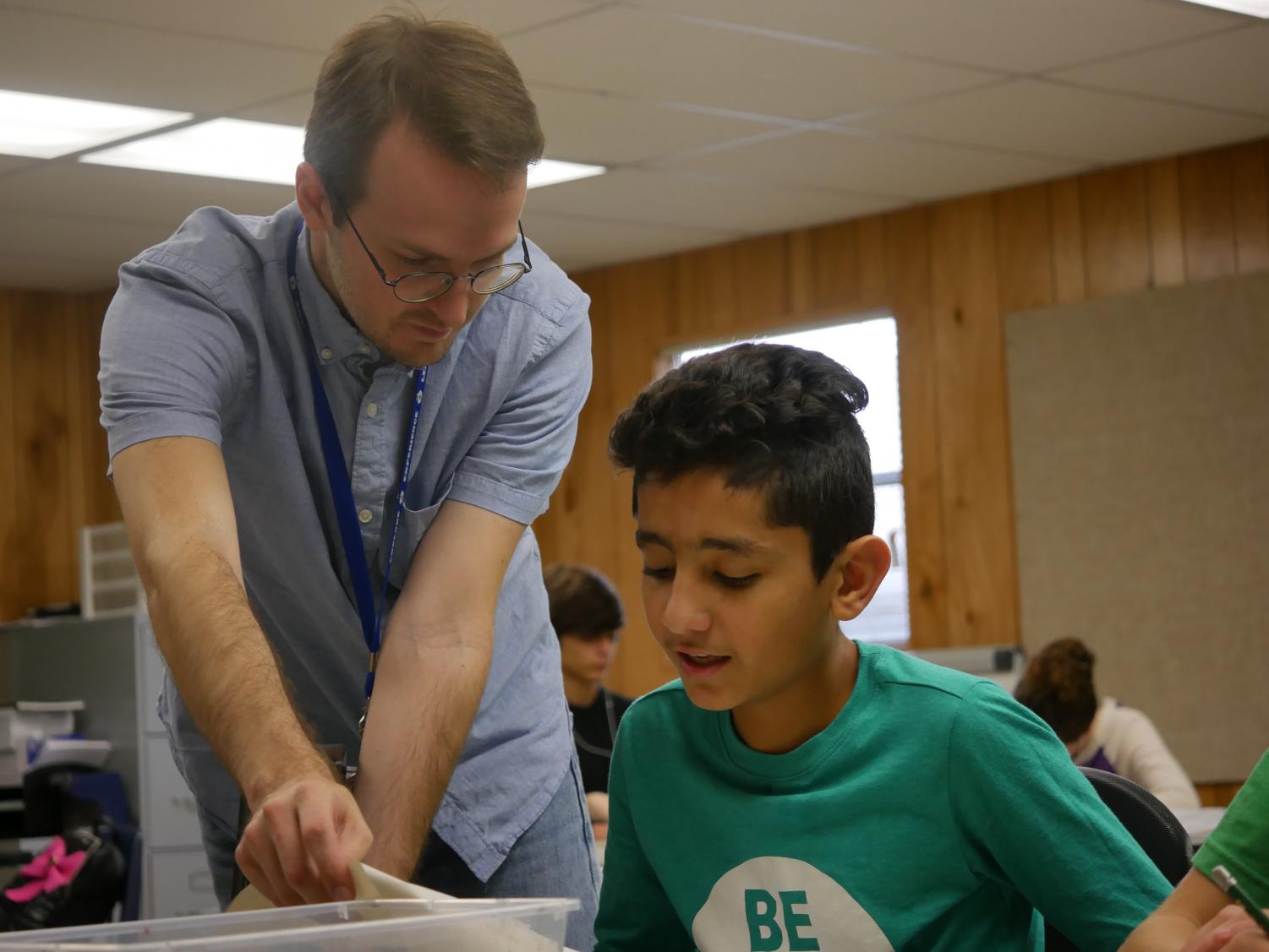 Andrew Cooke works with a student in his first-period Art 1 class. Cooke was a teacher aide at McCallum last year, and now teaches Commercial Photography 1 and Art 1 full time. He plans to expand into Advanced Commercial Photography next year. Photo by Janssen Transier.