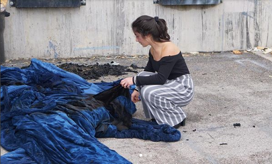 Sophomore Bela Tapperson inspects the charred curtain Tuesday morning. Tapperson was shocked when she saw the Austin Fire Department's post about the second fire on twitter. "I thought it was a mistake at first," Tapperson said. "There were like 6 fire trucks here [yesterday] and we thought they put it all out." Photo by Kelsey Tasch.