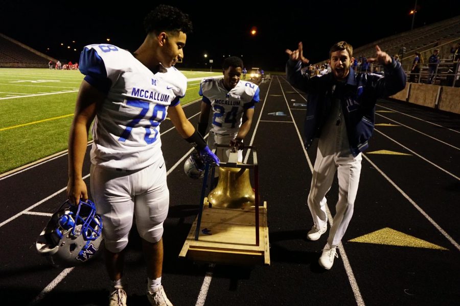 Sophomore Charlie Pecina and junior Caleb Brown wheel the bell towards the team bus after the Knight 63-0 win over the Travis Rebels on Friday. The win marks the 19th time the Knights have taken home the bell in the past 20 years. Photo by Caleb Melville.
