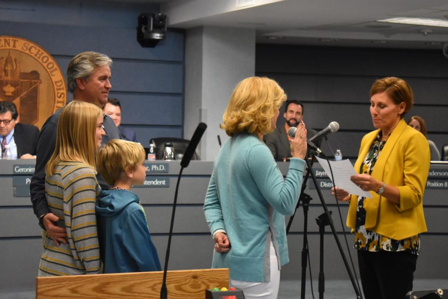 Kristin Ashy, who recently was elected to the Austin ISD Board of Trustees representing District 4, is sworn in by exiting District 4 representative Julie Cowan while her husband and children watch from behind. Photo by Olivia Watts.