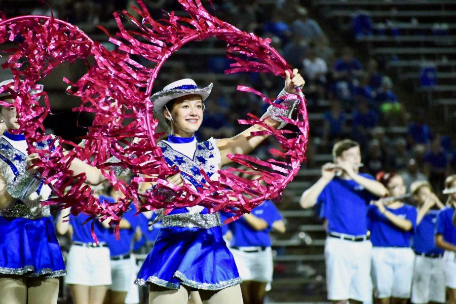 NO. 10 -- DO YOU REMEMBER (THE 21st NIGHT of SEPTEMBER)? Sophomore Addie Seckar-Martinez and her Blue Brigade teammates dance with pink hoops along to music played by the band during the halftime show at the LBJ football game on Sept. 21 at Nelson Field. Photo by Bella Russo.
