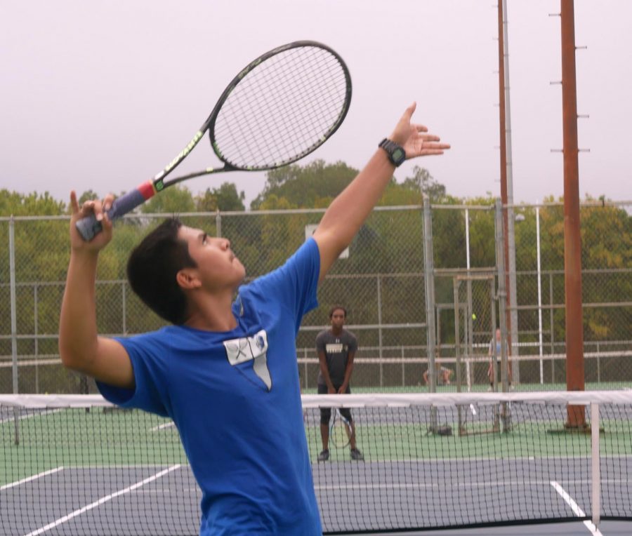 SERVING A WIN: Junior co-captain Richard Hernandez serves the ball during a singles match against Lanier. The tennis team beat Lanier with a score of 10-1 matches but lost to LBJ, 0-10 matches at the District Tournament. Coach Oakley Barber encouraged the team to play and have fun but not to worry about winning. They return to the courts to play Lockhart after school tomorrow in their final matches of the fall season.