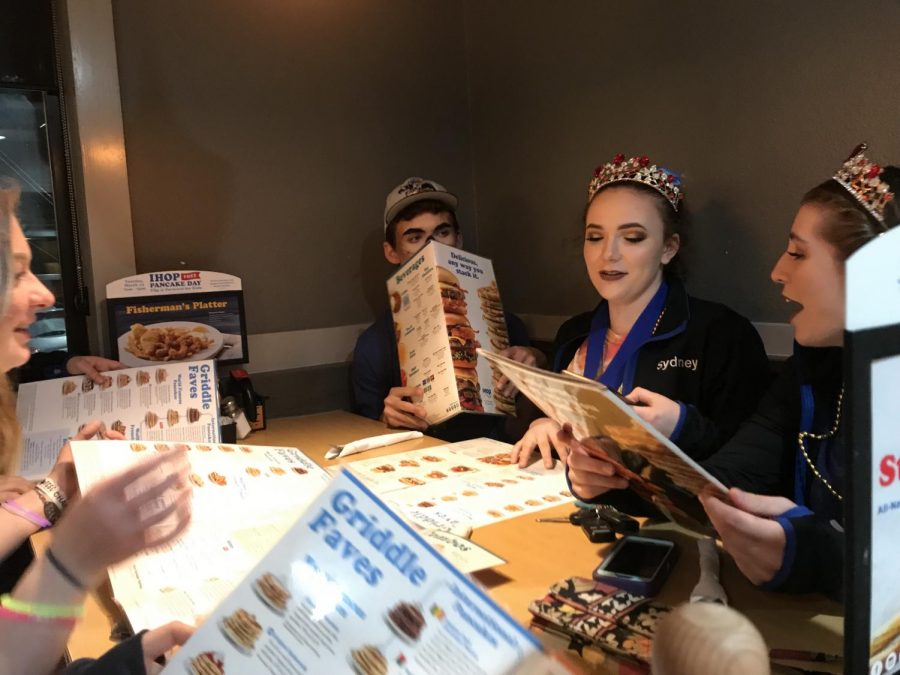 Seniors Emily Freeman, Sydney Bunce, Claire Rudy, Helena Sandberg and Henry Stanford sit together at iHop. It is their last time celebrating at iHop and they are taking the night to remember their three years of winterguard. “Guard has changed my life,” Freeman said. “Its been such a positive experience and has changed how I approach problems and my work ethic.” Photo by Grace Van Gorder.
