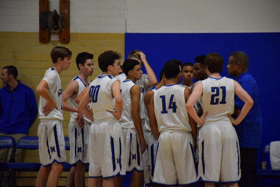 Coach Caldwell, far right, talks to his 2015-2016 varsity team after a tough loss to Del Valle Nov. 17.  The Cardinals clipped the varsity Knights 73-55, but the JV squad won its game over Del Valle, 57-55, in the final second. 