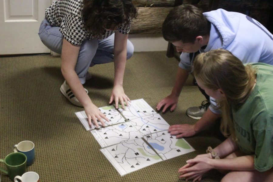 Sophomore Bella Russo, senior Steven Tibbetts and sophomore Ellen Fox work together to map out their location. This was one of the many steps required before the group could escape. Photo by Elisha Scott.  