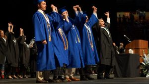 Mr. Garrison links pinkies with the leadership of the Class of 2018 as they sing the school song at the close of last years graduation ceremony. Garrison has one more song to sing: Wednesday night at the Erwin Center with the Class of 2019. 