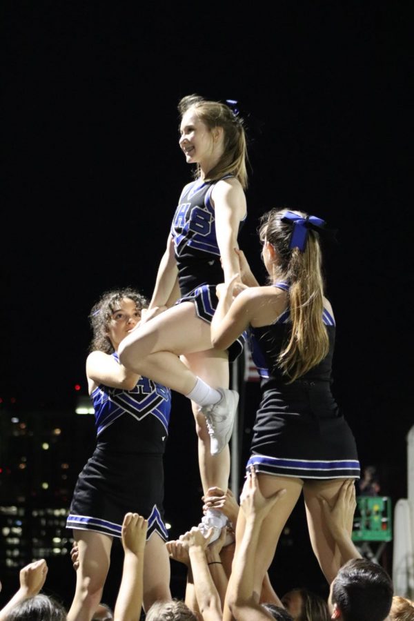FLYING COLORS: Freshman cheerleader Kate Bachman shows her McCallum spirit by being a flyer in a cheer routine. In the picture, she is doing a brace extension liberty. It was my first year flying, and it was such an energy rush, Bachman said. We may not have won the game, but we won the [award for having the] most spirit! 