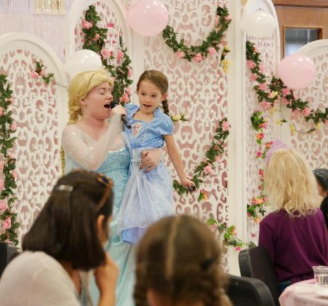 SEEING DOUBLE: Senior Maryanna Tollemache and another, smaller Princess Elsa sing “Let it Go” for a crowd of other princesses and their parents. Due to the wireless microphones used this year, Tollemache and the other actors were able to better interact with the kids. “It’s always unique due to the kids who come and the cast,” Tollemache said. “I love seeing the kids get excited. They would all circle around and begin to sing with me and I just loved seeing how happy they are!”