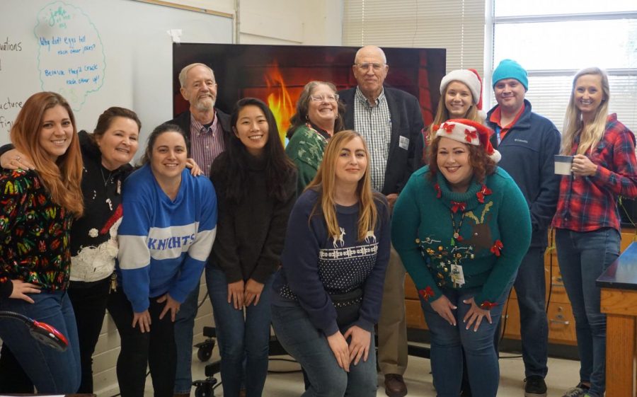 The science department, including former science teachers Robert Lehman and Richard Whisennand, pose for a group photo at the annual department holiday party on Wednesday, Dec. 18, in Mr. Ely's room. Photo by Lindsey Plotkin.