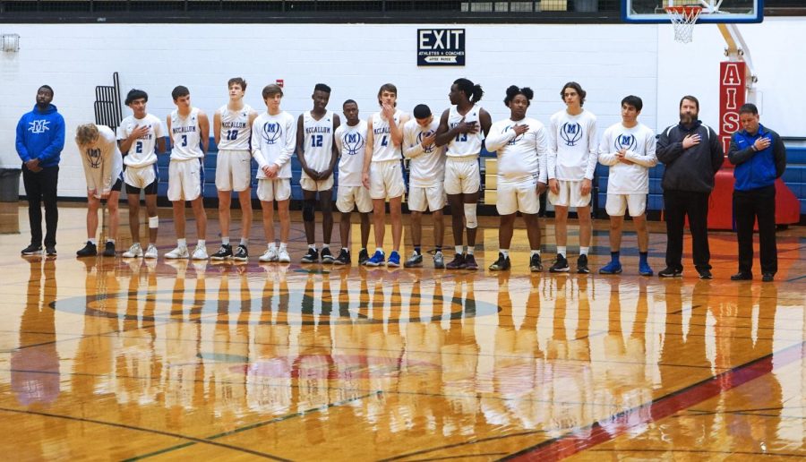 Flanked+by+their+coaches%2C+the+players+of+the+boys+varsity+basketball+team+stand+for+the+national+anthem+before+the+played+Pflugerville+Weiss+at+the+Delco+Center+on+Dec.+20.++Albert+Garza+drove+down+the+center+lane+and+converted+a+buzzer-beating+layup+to+send+the+game+into+overtime+where+the+Wolves+prevailed%2C+54-51%2C+in+a+non-district+game.+Photo+by+Annabel+Winter.