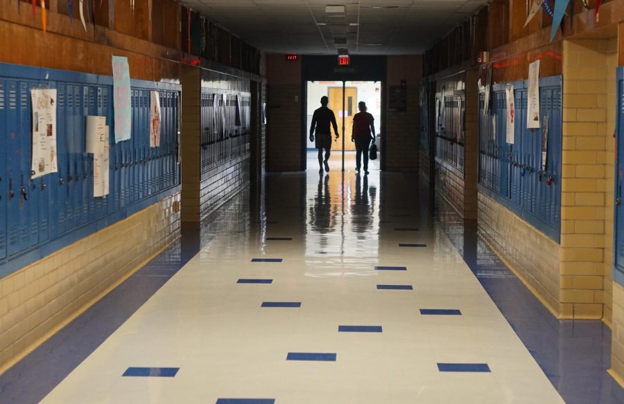 Susan Ashton and her son walk the hallway to her math classroom late this morning. Ashton brought her son with her in order help her bring home school supplies so she can work from home to conduct online classes. Ashton said she brought home an office chair, a printer and a document camera. While she was on campus, school officials received word of the city of Austins stay at home order which prevent citizens from leaving their homes for non-essential activities beginning at midnight tonight. Prior to the order, teachers were able to come to campus today, five at a time if they had signed up for a 30-minute time slot the day before.