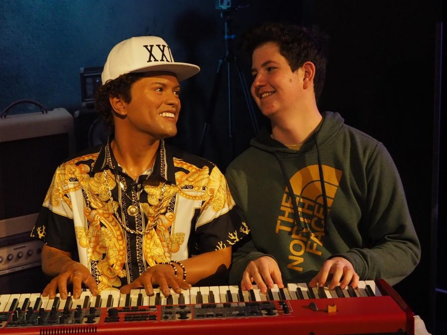 MAKING MUSIC WITH MARS: Junior Luke Lozano laughs as he poses for a photo with a wax figure of Bruno Mars at Madame Toussads Wax Museum — one of the many excursions made on last years Nashville piano trip. Lozano stated that the day was filled with lots of silly photos posed with the life-like celebrity figures. Photo by Gregory James.