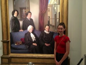 Samantha poses with a portrait of all the female Supreme Court justices at the National Portrait Gallery during her familys visit to Washington DC in the summer of 2018. Samantha hopes to one day join that hall of fame as a woman serving on the highest court in the land alongside her idol, Justice Ginsburg. Photo courtesy of Samantha Powers.