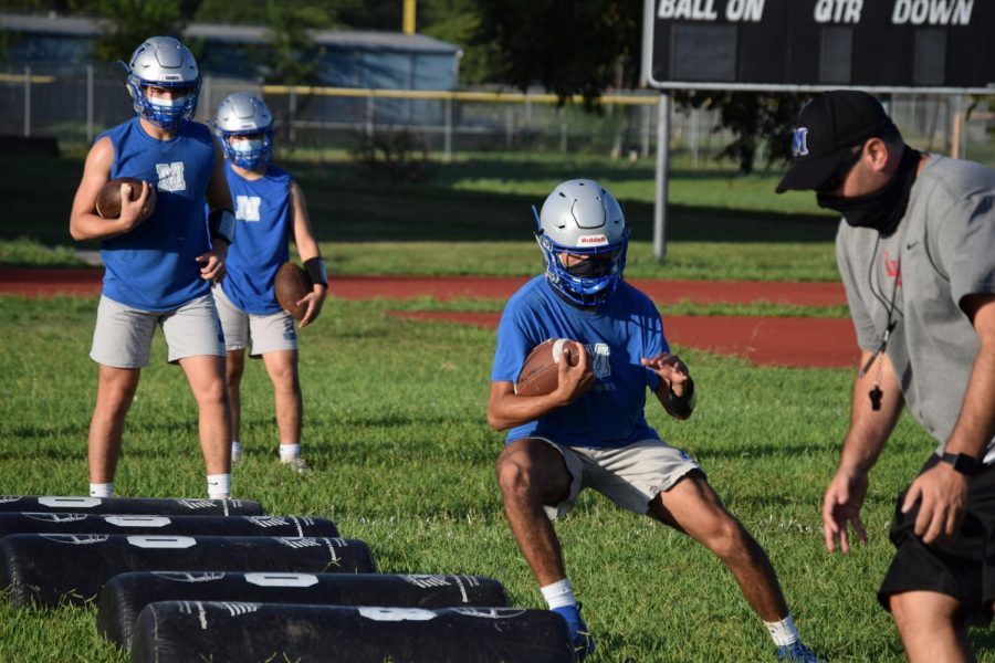 Prepping his players, Coach Webb runs conditioning drills with members of the football team during their first practice of the season after a six month hiatus from training. Photo by Lindsey Plotkin
