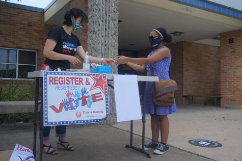 With the help of League of Women Voters Club volunteer Stephanie Land, senior Vanessa Lee registers to vote during the curbside voter registration drive in front of the main entrance of the school on Sept. 18. The club registered 10 voters (nine students) during the drive that day. 