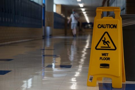 A caution sign stands in an empty hallway on the Friday to end the first week of school. So far all learning has been virtual, but some students will return to campus starting Oct. 5.