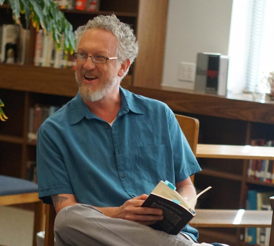 Myers reads original poetry at an early morning faculty poetry sharing session in the Mac library on April 24, 2018.