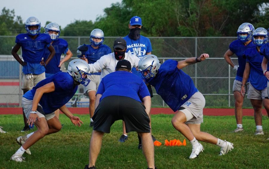 Athletic teams such as the football team shown here are following safety protocols such as wearing facial masks and practicing social distancing during weight training and team exercises, but sports, especially football, volleyball and basketball,  require contact and close proximity between athletes, which increases risk of exposure to COVID-19.