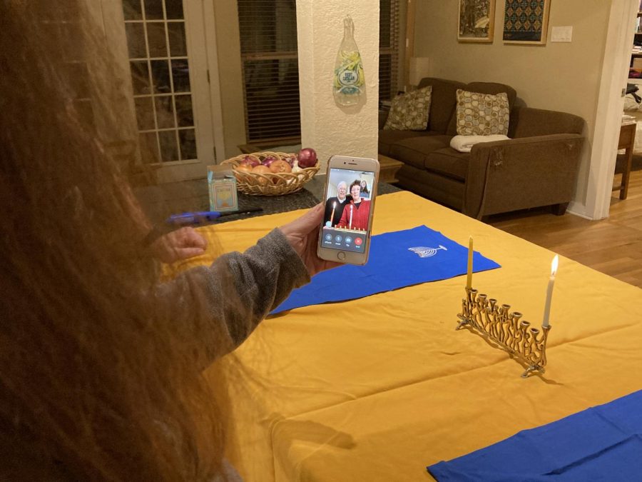 FESTIVE+FACETIME-+After+reciting+the+Hanukkah+prayers+and+lighting+her+menorah+the+first+night+of+Hanukkah%2C+Carolyn+Schwarz+talks+with+her+parents%2C+John+and+Rhoda+Schwarz+over+Facetime.+Usually+the+Schwarzes+would+gather+in-person+to+celebrate+Hanukkah%2C+but+due+to+the+safety+concerns+of+coronavirus+they+decided+to+take+part+in+the+festivities+virtually+this+year.+%E2%80%9CHaving+older+parents+and+knowing+the+health+risks+the+virus+could+have+on+them+made+our+holiday+plans+very+clear%E2%80%9D+Carolyn+said.+%E2%80%9CWe+knew+that+physically+getting+together+would+not+be+a+safe+option+this+year.%E2%80%9D+Carolyn+celebrated+the+holiday+at+home+with+her+husband+and+children+while+her+parents+celebrated+with+their+dog%2C+Winston.+%E2%80%9CSo+much+is+different+this+year%2C%E2%80%9D+Rhoda+said.+%E2%80%9CIt+is+a+blessing+that+we+can+still+celebrate+with+each+other+in+some+way.%E2%80%9D+