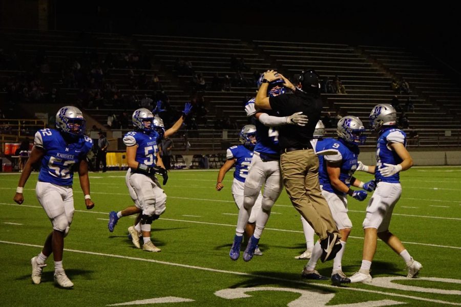 LEAPS AND DOWNS: Coach Chris Russell and junior safety Jake Hissey celebrate after Hissey’s tackle forced a turnover on downs in the second half of the Knights’ 14-0 victory over district opponent Marble Falls at House Park on Nov. 5. The Knight defense stifled the Mustang offense throughout the game and created three turnovers on downs in the second half alone.