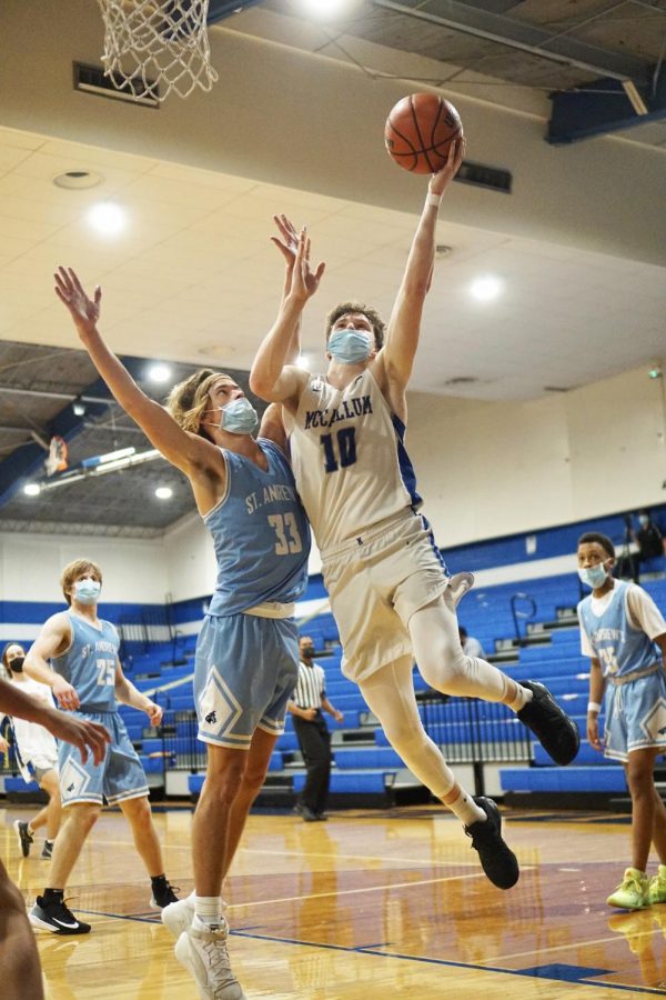 SOARING HIGHER THAN THE HIGHLANDERS: Senior captain Rob Wade shields a St. Andrew’s defender with his body to create space for a left-handed shot attempt during the Knights’ 59-51 home victory over the Highlanders on Friday night. Wade led the Knights to victory with 22 points. The Highlanders brought their A game, but the Knights answered with the same high level of play. The home team went into halftime up by one, 26-25. In the second half, the Knights picked up speed and pulled ahead for an eight-point final margin of victory. “We fought well through adversity. St. Andrews never went away or quit and we did a good job of answering them both defensively and offensively.” Wade said. “We’re just going to continue to work hard and make each other better.”