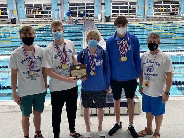 The region champions in the 200-yard medley relay race and their coach pose with their gold medals and championship plaque after the race. Senior Kyle Larson (backstroke), senior Izak Zaplatar (breaststroke), sophomore Luke Gordon (butterfly), senior Jack Hester (freestyle) and head coach Jeff Rudy. 