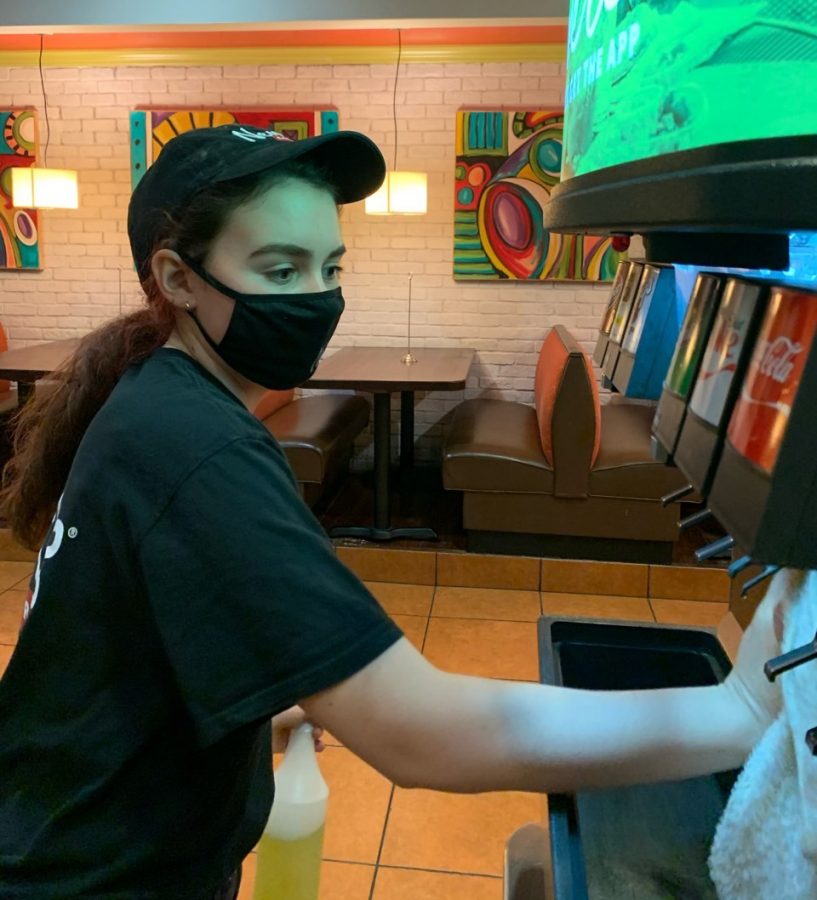 Senior Bridget Russo, who works at Newks Eatery, wipes down the soda fountain during her shift.