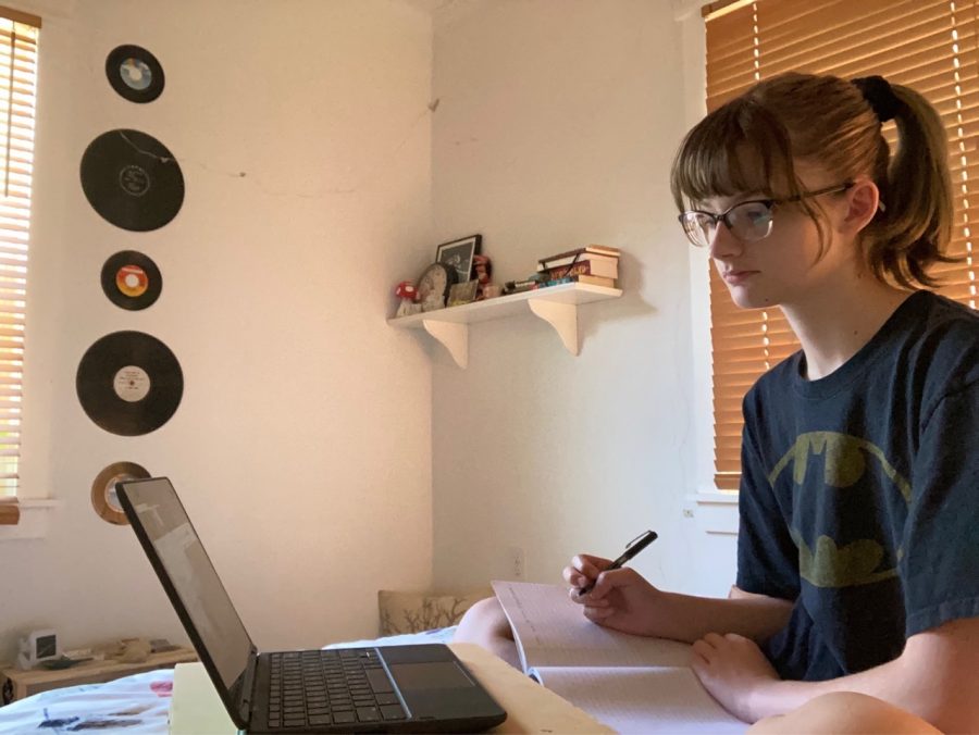 Paying close attention, freshman Naomi Pearson takes notes during her fourth period geometry Zoom. During class, Pearson prefers to have her camera off while her teacher gives direct instruction because it allows her to focus on her work without the distraction of her appearance.