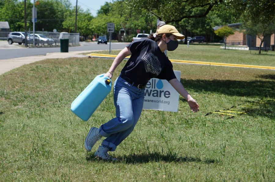 Senior PAL Bella Russo makes a sharp cut in the grass as she veers around the Well Aware sign nearing the halfway point of the water walk obstacle course.