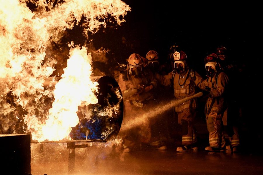 WEEKEND FIRE DRILL: Students from the LBJ Fire Academy work their way towards a propane fire on Oct. 3, using fire hoses to control the blaze. The purpose of the drill wasn’t to put out the fire, but to use the spray to get close enough to the propane tank to turn off its fuel source. Five McCallum seniors, John Hughes, Thomas Lucy, Tex Mitchell, Molly Odland and Will Russo, participated in the live fire skill day, where they put into practice what they’ve learned during the two year student-sharing program at LBJ High School. “Being in the live fire gave me really intense adrenaline,” senior Molly Odland said. “I was the head of my group, meaning I was in charge of directing the hose line at the fire while my group supported me from behind.” Senior Will Russo, who also had the chance to lead the group, said that the drill felt like being in a hot car. “It wasn’t all that scary since you were with a bunch of people, but it was kind of intimidating because there was nothing in between you and the fire but water,” Russo said, before adding that “the propane smelled kind of like pumpkin spice.”  The next live fire the students will tackle will be a class A structure fire later in the month, before beginning EMT certification training in the spring. 