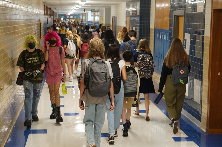 CROWDSOURCING: Arwen Frederiksen (far left) walks down the hallway before school starts to re-familiarize themselves with the campus. “[The hallways] were definitely busier than I expected,” Frederiksen said. After almost a year and a half of virtual learning, Frederiksen expresses how they are simply happy to be around other people once again. “I haven’t seen a bunch of my just school friends in forever,” Frederiksen said. “It was great.” Reporting by Alysa Spiro.