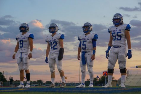 CAPTAINS AT TWILIGHT: Seniors Ez Guenther, Jake Hissey, Jaxon Rosales and Johan Holmes lineup for the coin toss before their last non-district game against the Kerrville Tivy Antlers. For Hissey, it was his first game back after suffering a wrist injury before the team’s marquee matchup against the Anderson Trojans. Despite wearing a cast that prompted the opposing coaches to urge their offensive skill players to run at the one-armed safety, Hissey held his own, nearly making an interception to seal the victory on the play before Guenther succeeded in doing the same. The Knights went on to beat Tivy 23-15 in a game that despite Tivy’s 0-4 record, they were not favored to win. Caption by Thomas Melina Raab.