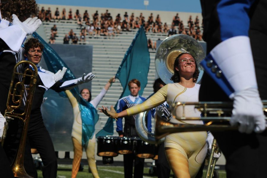AND CUT: Members of the color guard eagerly motion their hands towards their captain, Natalie Nagy, in the closing moments of “Mirage.” During the Capital City Marching Festival, the guard earned a second place title in the preliminary round. “We crushed it,” color guard member Ella Jones said. Reporting by Grace Vitale.