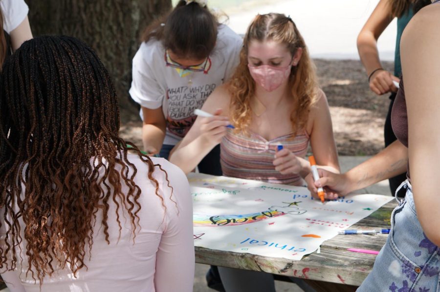 PREPARING FOR PALS: Senior Zoe Lynch (center), senior Marina Garfield (left) and junior Caytie Brown (far left) join their fellow PALs on Aug. 30 in writing their shared values and goals for the coming year on a poster. “The PALs were making posters about PAL norms and what it means to be a PAL,” Lynch said. As a second-year PAL, Lynch is most excited to visit and interact with the elementary schoolers. “Last year we had to do it over Zoom,” she said. “It was definitely a lot harder to interact with them because kids don’t really want to stay in Zoom longer than they have to.” Lynch and the PAL team will continue to apply their “norms” to their work and projects this year including the annual Pink Week campaign to raise awareness and money for the Breast Cancer Resource Center of Austin. Caption by Lucy Marco. 