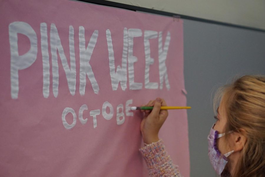 STARTING TO THINK PINK: Senior Anna McClellan paints a sign to promote Pink Week on Sept. 22, the first day the PALS started prepping for Pink Week. In addition to making promotional posters, McClellan and the other members of the PALS communications committee helped to get the word out by creating graphics. “It was a great start to the process on the communication committee role to get the word out, McClellan said. Just being able to make posters and get the word out while being creative was really fun.” But this years Pink Week meant more to McClellan, the PALs and the entire campus this year. “Being able to bring back the water balloons and the trinket sales and bring back the MAC spirit that we missed last year due to COVID and being able to experience that spirit again was really great especially for the upperclassmen who had experienced it before COVID hit.” Caption by Dave Winter.