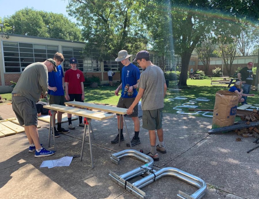 Volunteers from Braden Roeders Boy Scout troop help to build a bench for the English courtyard.