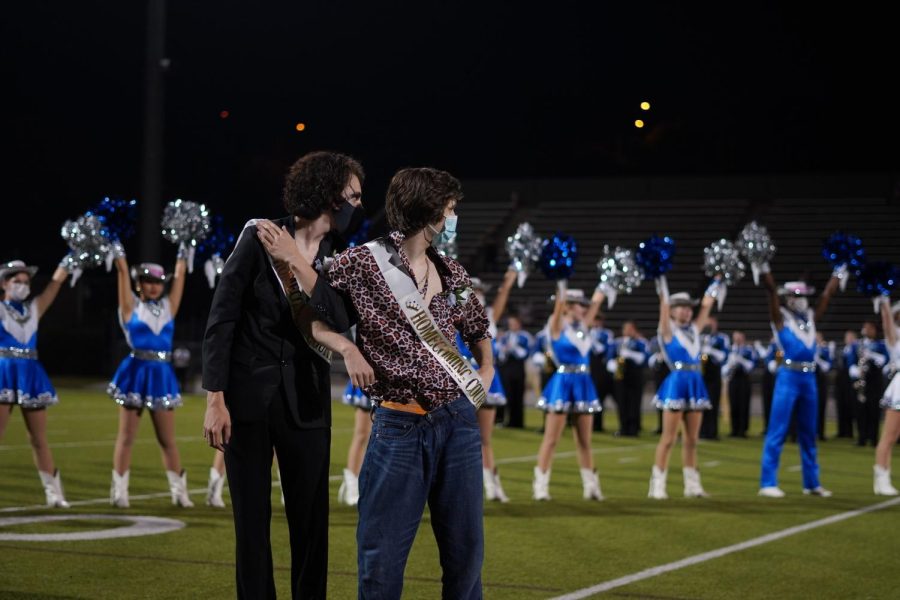 Juniors+Dylan+Neal+and+Mason+Michulka+walk+across+the+House+Park+field+during+halftime+after+being+crowned+Class+of+2023+homecoming+royalty.