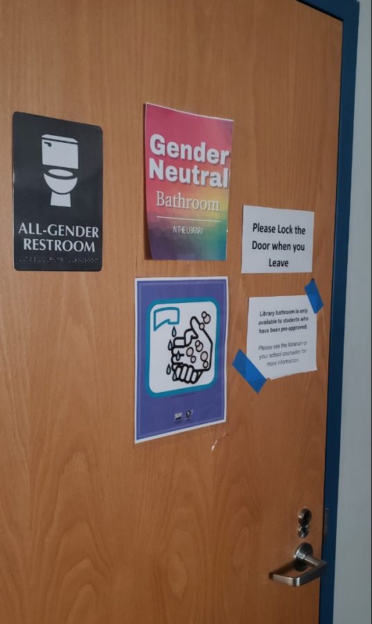 The bathroom door at the back of the library informs students of its gender-neutral but permission-only nature.