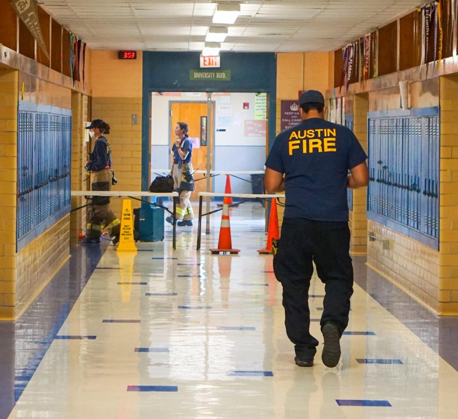 Austin firefighters investigate the girls restroom on the University Boulevard hallway, the site of a trashcan fire that prompted the evacuation of the campus today during fourth period.